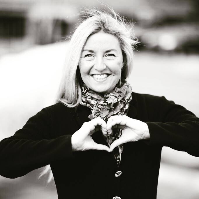 Photo of Michelle Mejaski smiling and making a heart with her hands